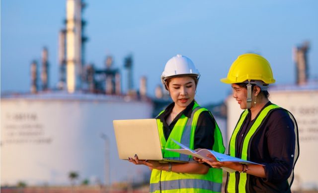 Two female engineer discussion together at refinery industry plant