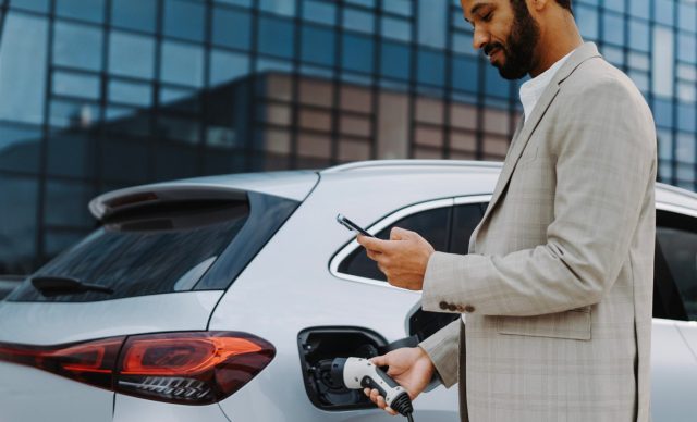 Young businessman charging his car