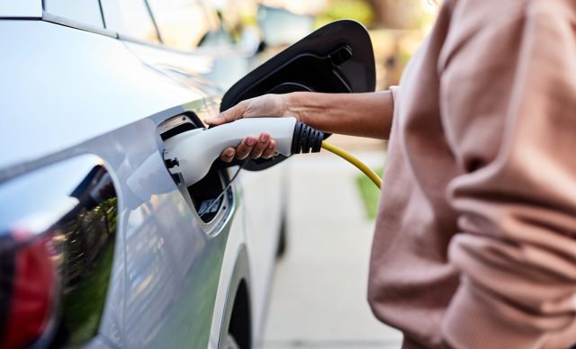 Woman charging electric car
