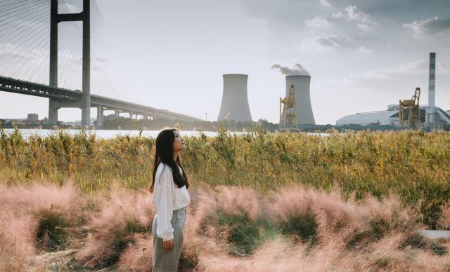 Asian woman standing near cooling tower