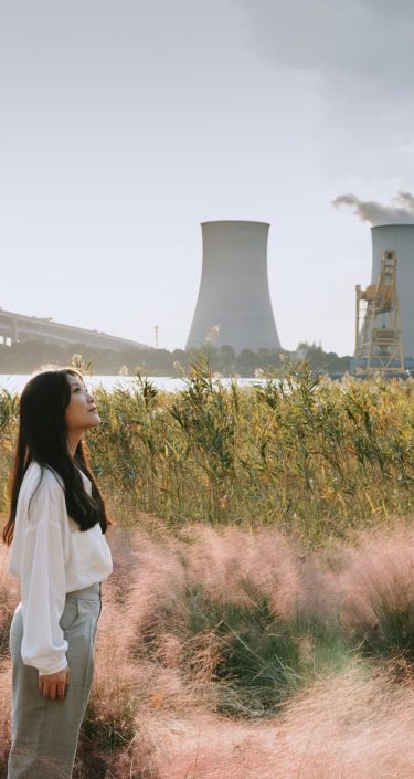 Asian woman standing near cooling tower