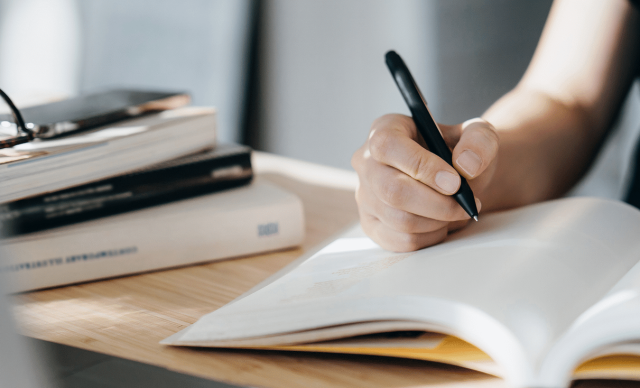 Asian woman writing on a book