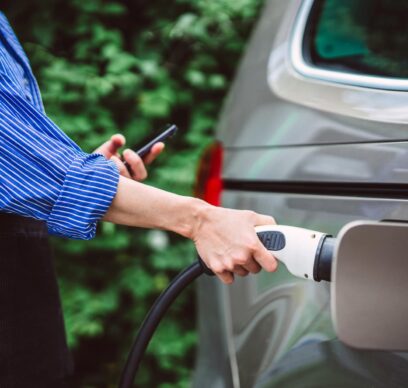 Woman charging her electric car at EV charging station