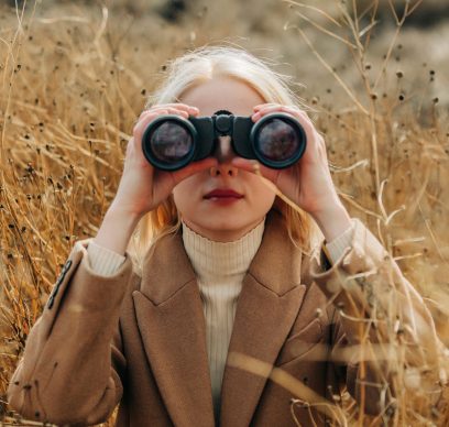 Business woman looking through binoculars